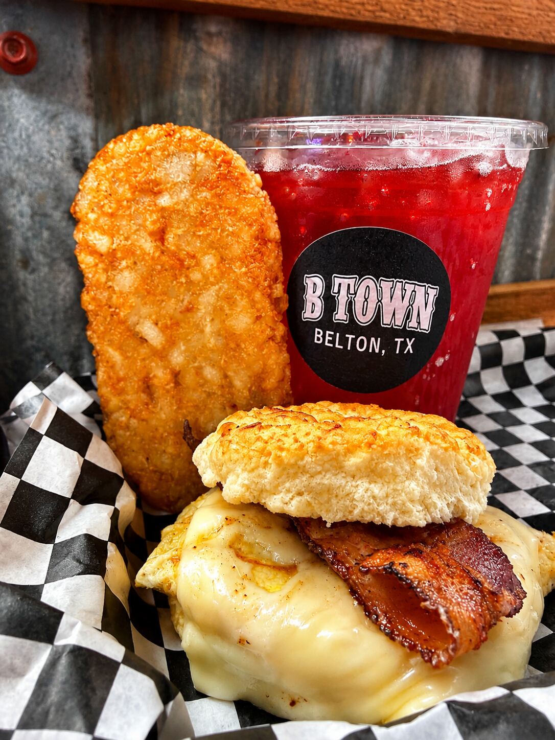 Bacon egg and cheese biscuit with hash brown and red drink