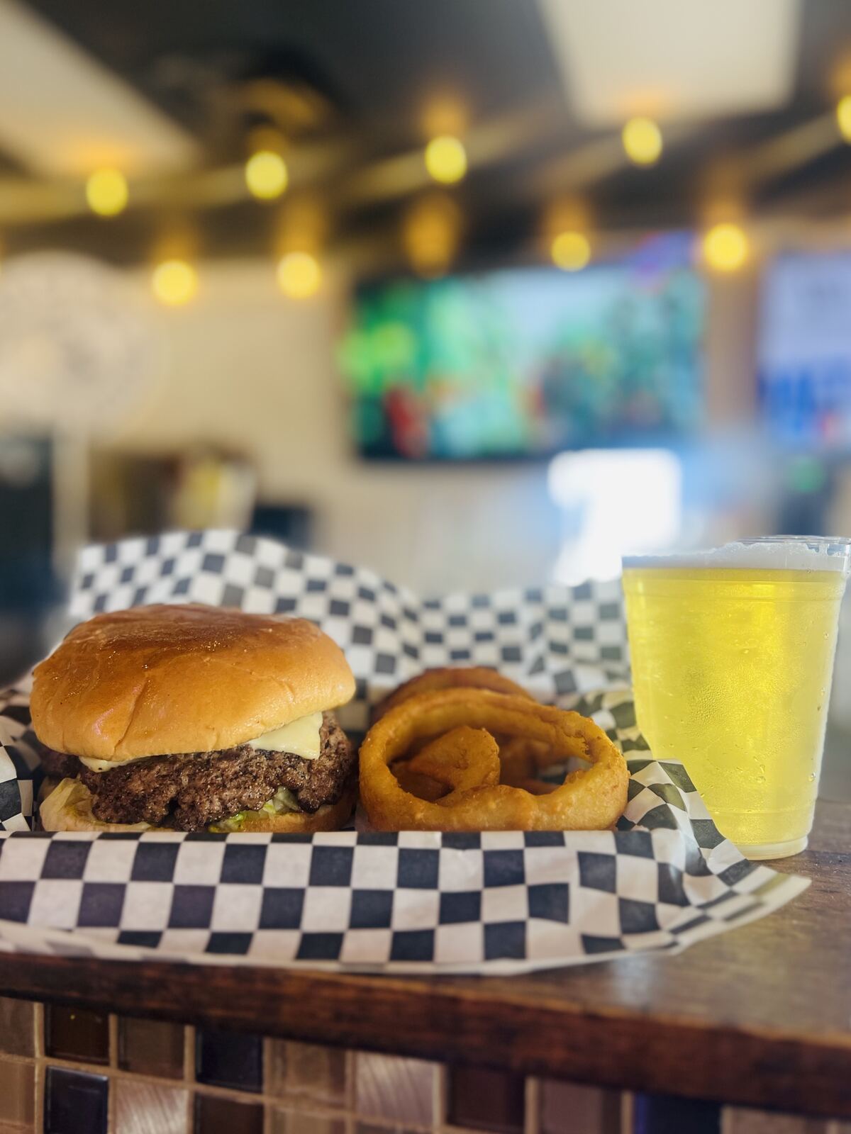 Cheeseburger with onion rings and a cold draft beer
