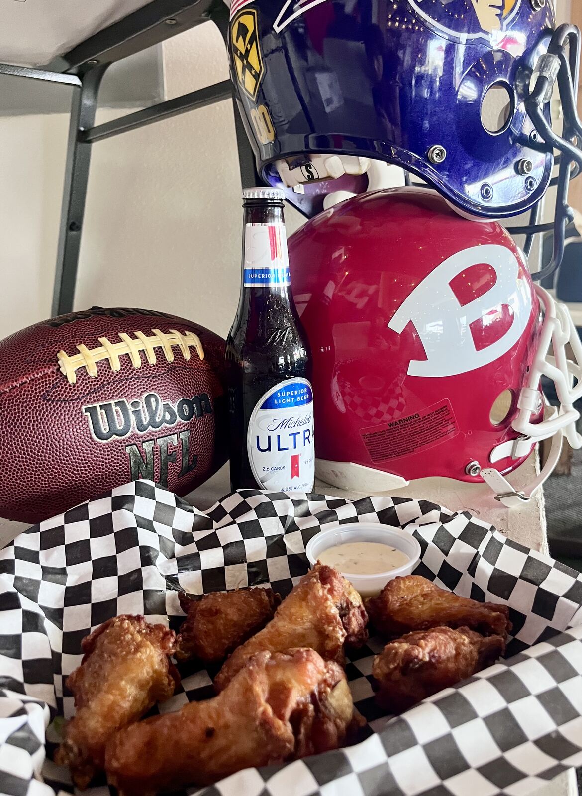Chicken wings with ranch, football and helmets in the background